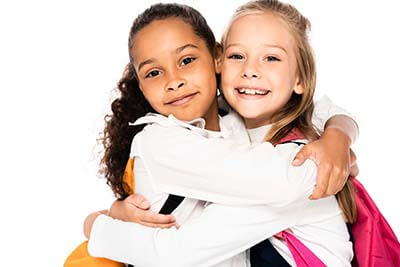 Young school age girls hugging, friendship.